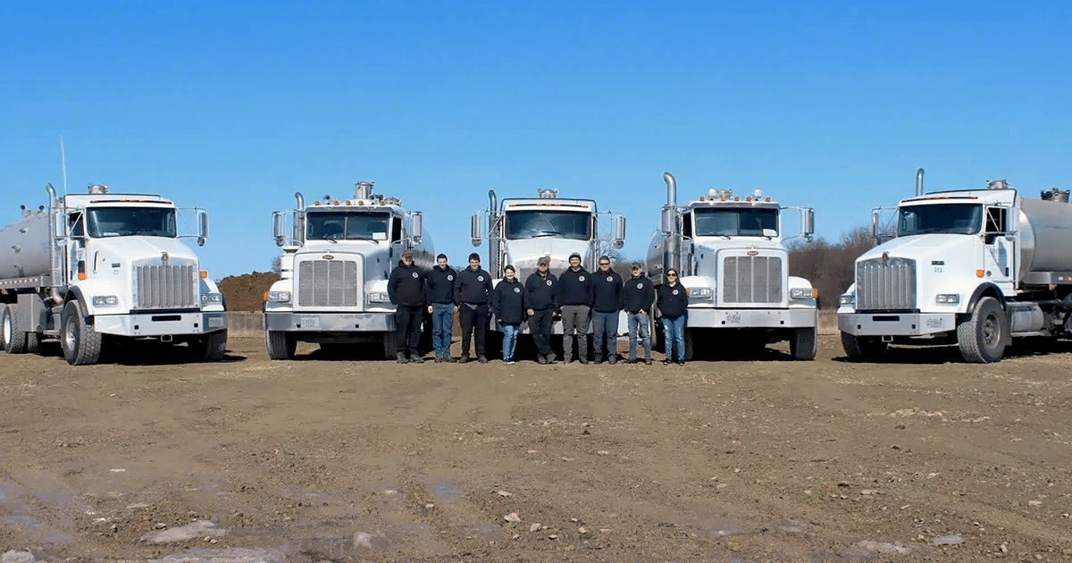 United septic and drain service staff in front of trucks.