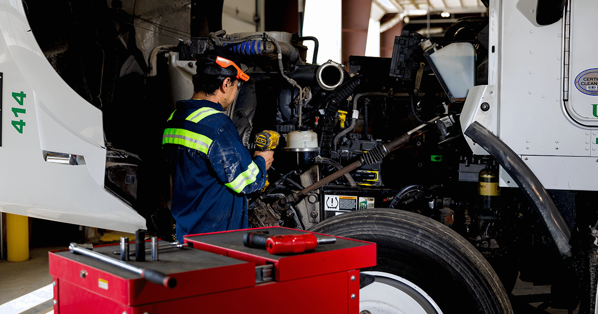 United staff member servicing a truck. Waste transport services